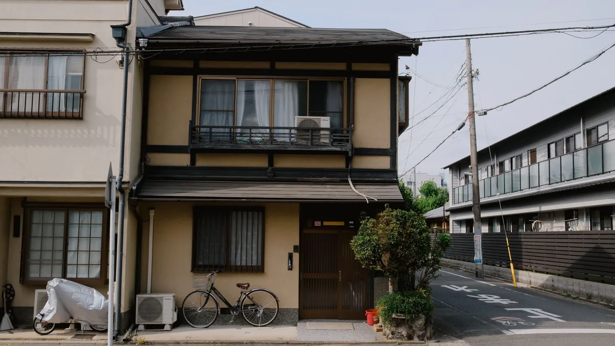 道路に面して建つ住宅の外観と前面の道路の様子